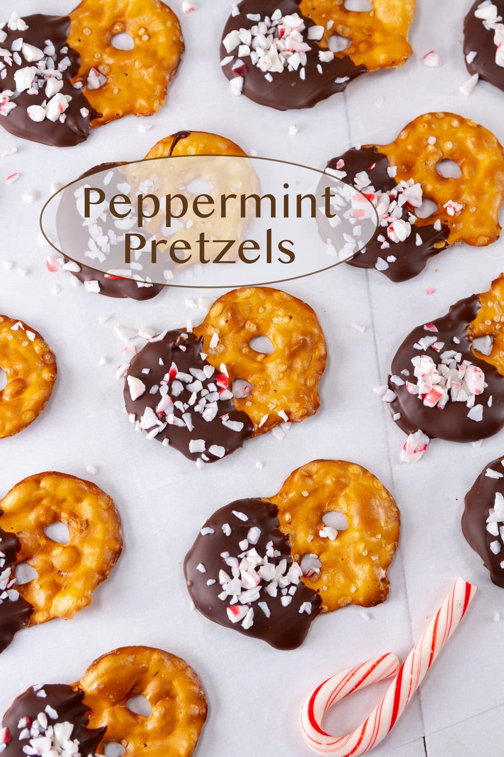 chocolate peppermint pretzels on parchment paper with a candy cane.