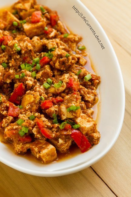 Braised Tofu in a full flavored vegan sauce. I give you: Copycat Chipotle Sofritos in the Slow Cooker or crock pot. This one is a keeper! a white serving platter with cooked tofu and veggies in it.