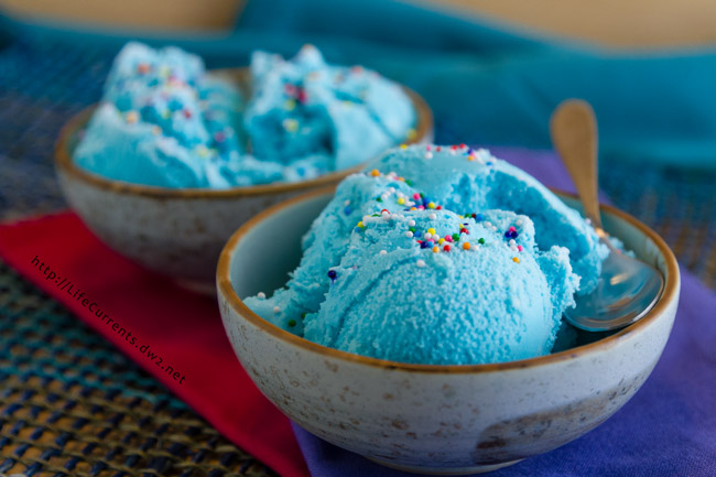 vanilla ice cream that's blue in color in a bowl with sprinkles on top.