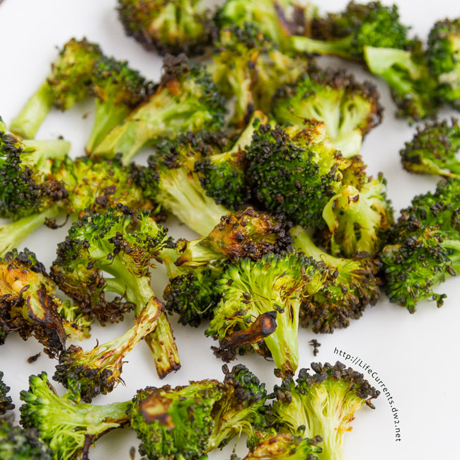 cooked broccoli on a white platter, close up.