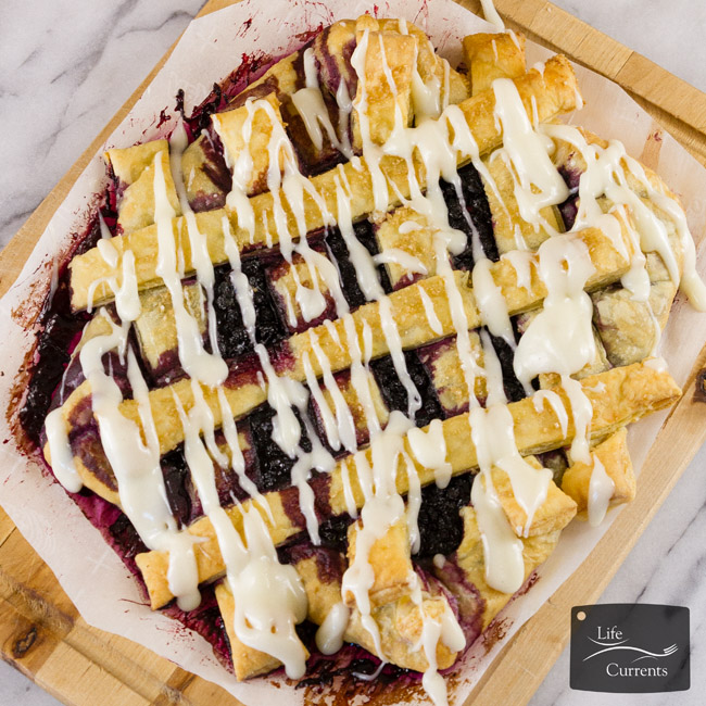 square crop of top down view of breakfast danish with blueberries.