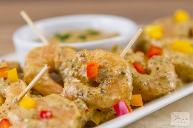 Shrimp in a sauce with toothpicks.