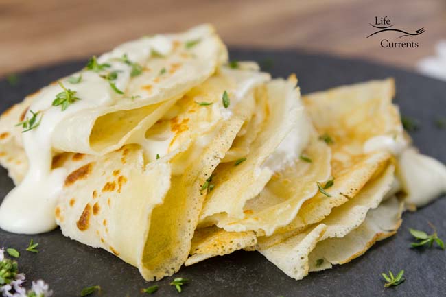 a stack of folded crepes on a slate plate.