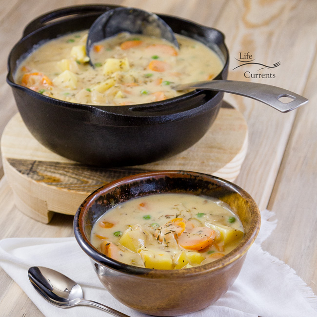 Mom&rsquo;s Vegetarian Pot Pie Soup in a bowl in front of the pot of soup with a ladle. 