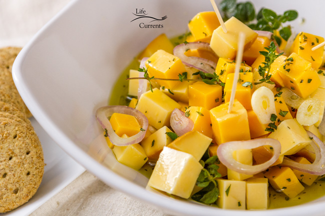 Marinated Cheese and Herbs Appetizer Recipe - easy and super delicious serve with crackers cheese with herbs in a bowl, crackers on the left side.