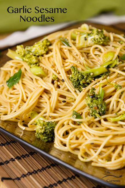 Garlic Sesame Noodles - Asian noodles with broccoli on a brown square plate with a green napkin in the background