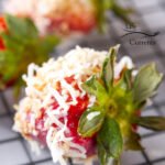 Coconut Dipped Strawberries - focus on one berry dipped in coconut wait to be nibbled on