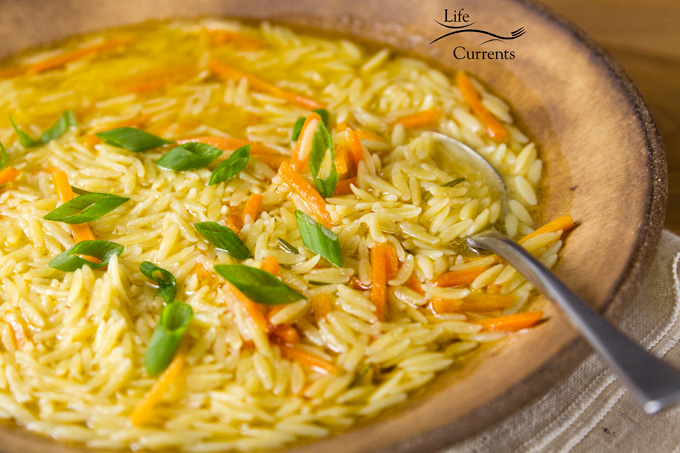 Rosemary Orzo Soup in a brown bowl with a spoon ready to eat
