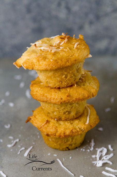 Gluten-Free Coconut Muffins stacked 3 high on a grey background