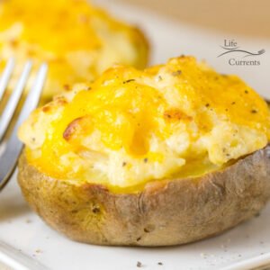 Twice Baked Potatoes - This simple, easy to make in the oven, potato side dish recipe is the perfect cheesy make ahead accompaniment to dinner that&rsquo;s also perfect for a crowd.