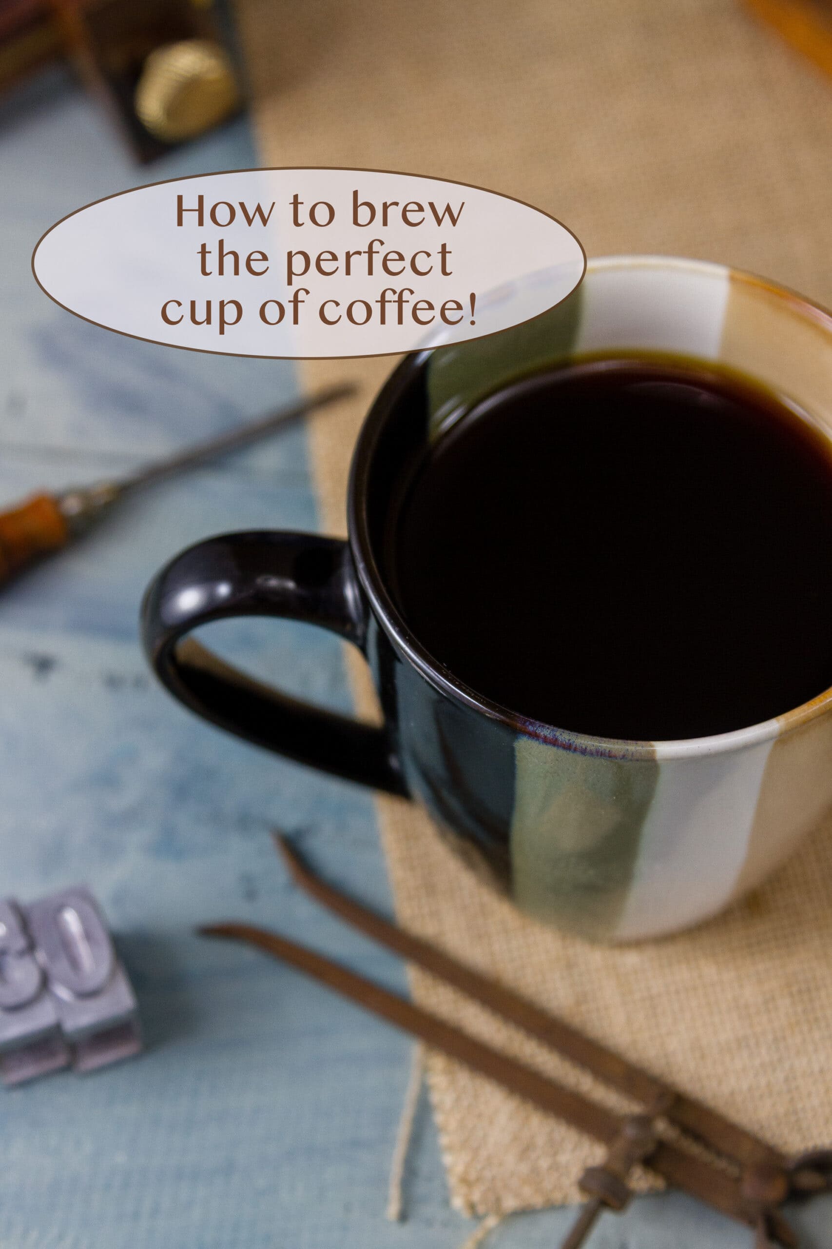 a cup of black coffee with some old tools around it.