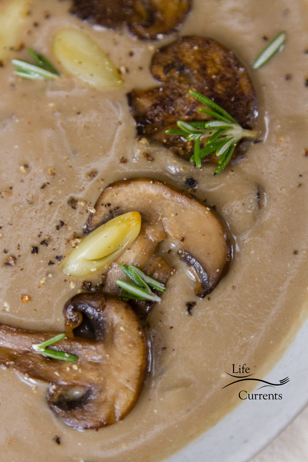 Roasted Garlic Mushroom Soup garnished with roasted garlic cloves and sauteed mushrooms