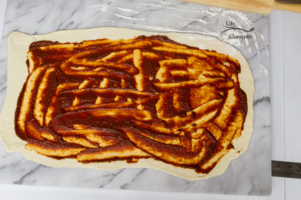 spread the pizza sauce over it 