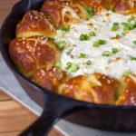 Skillet Pull-Apart Pretzel Buns with Creamy Cheese Dip - The ultimate tailgating snack! Soft pretzel buns made from scratch, baked with creamy cheese dip in the middle!