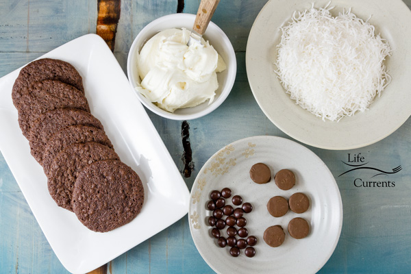Polar Bear Paw Cookies I love how cute these are! I also love how you can personalize these fun cookies. ingredients to make Polar Bear Paw Cookies laid out on white plates and bowls on a blue background.