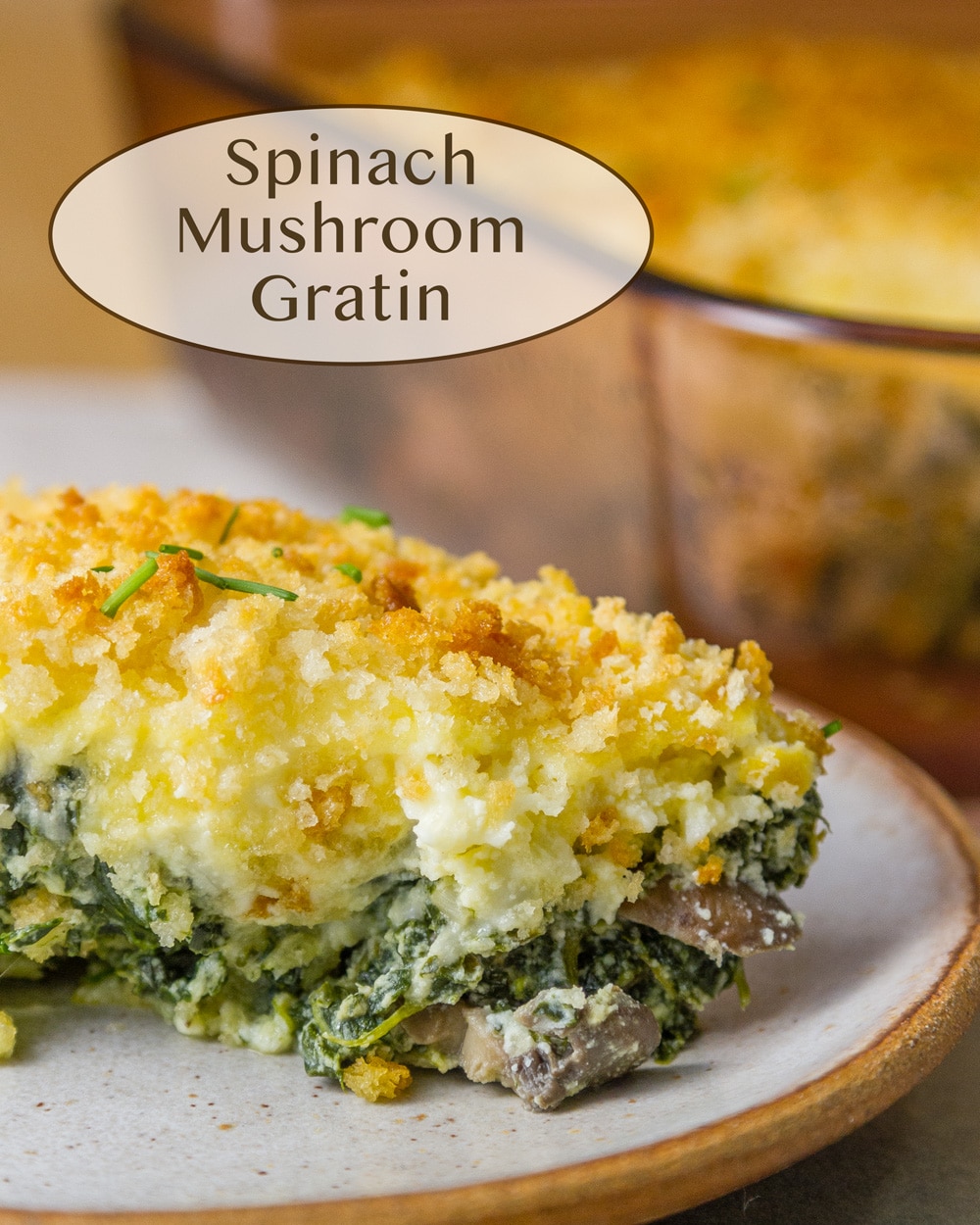 a slice of spinach mushroom gratin on a white plate in front of the serving dish.