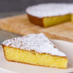 a slice of almond cake in front of the rest of the cake.