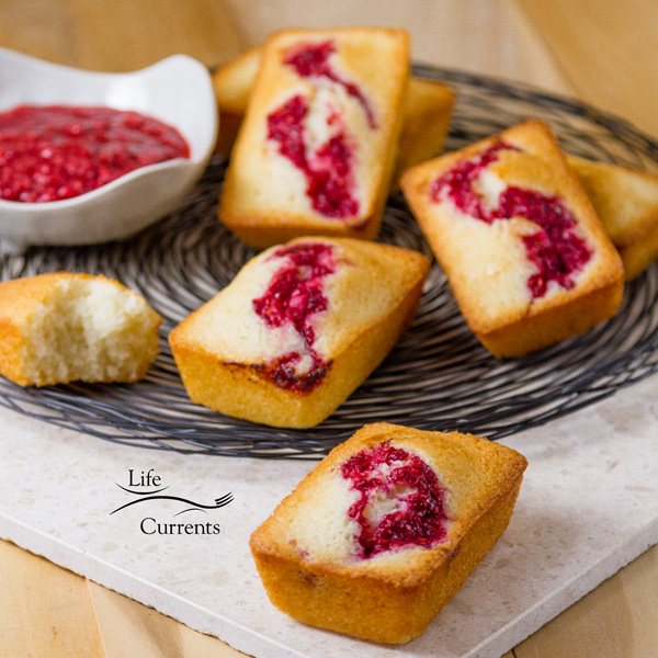 French Almond Financiers Cakes served with roasted raspberry sauce on the side all on a swirly wire rack