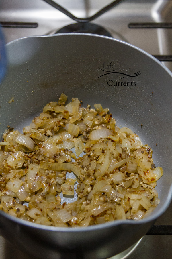 mushrooms and onions cooking in a pot