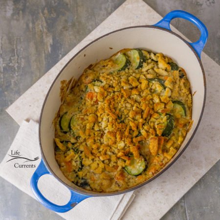 Zucchini Stuffing Casserole Recipe fresh out of the oven and ready to eat in the blue casserole dish on a white serving tray