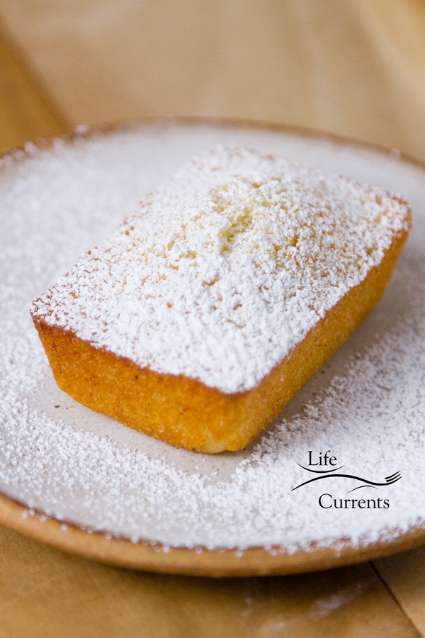 Financiers (French Almond Cakes) dusted with powdered sugar on a white plate