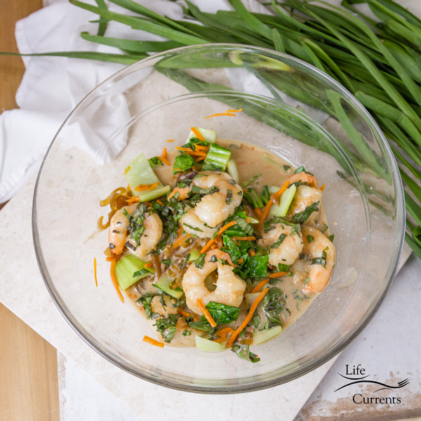 shrimp, veggies, and sauce in a large bowl ready to be stuffed into a sweet potato 