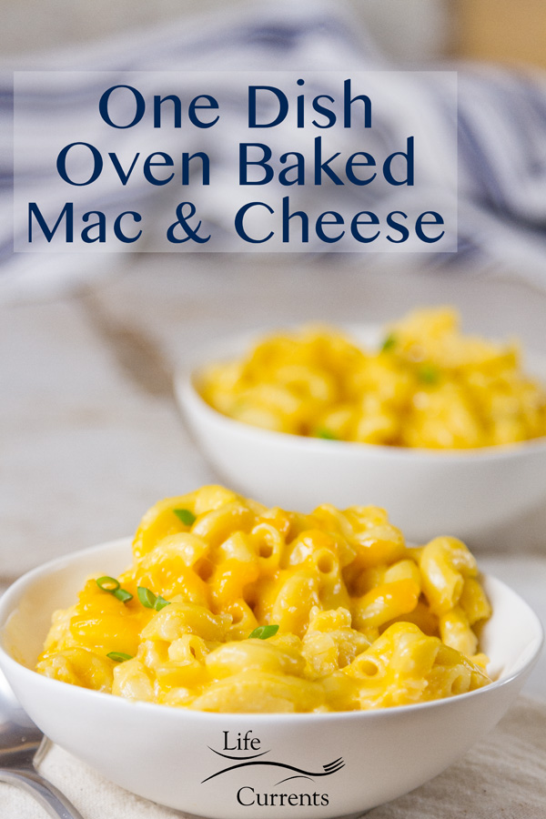 Two white dishes filled with homemade mac & cheese on a white background with a blue striped towel