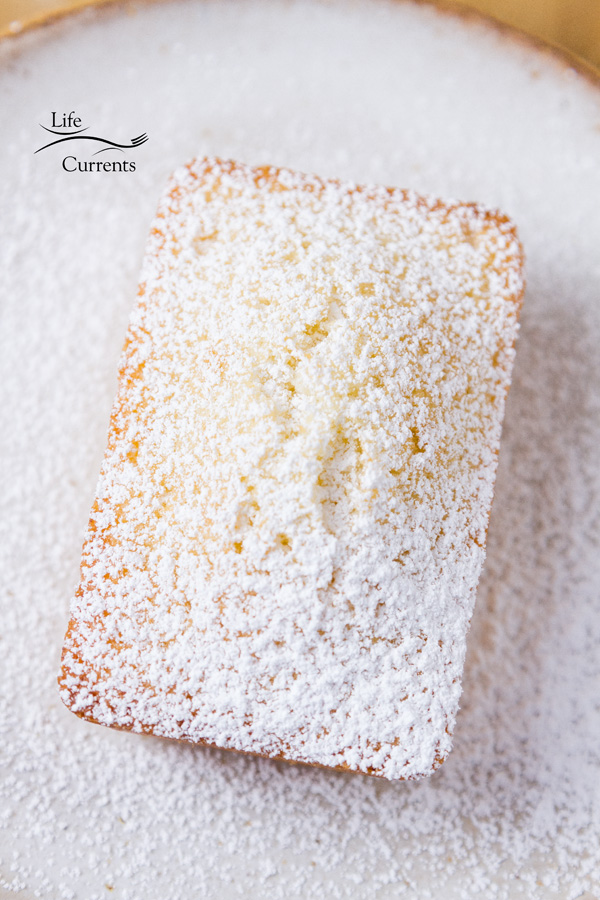 A tea cake dusted with powdered sugar on a white plate