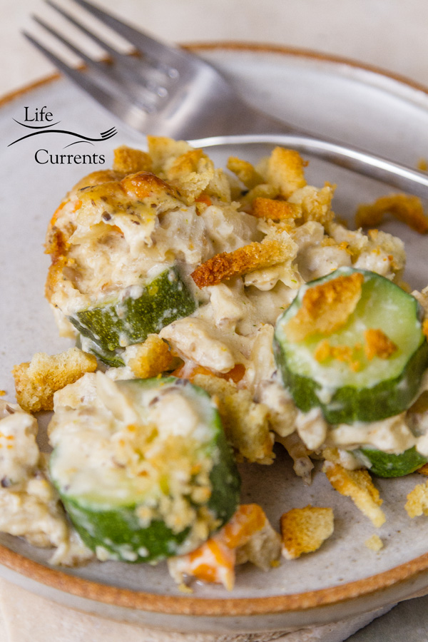 A serving of Zucchini Stuffing Casserole on a white plate with a fork
