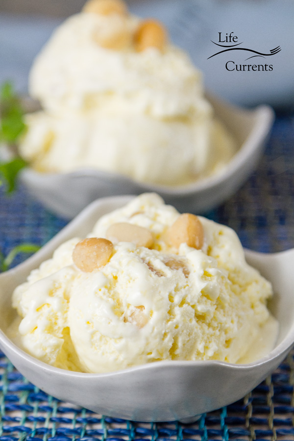 two servings of pineapple macadamia nut ice cream in white bowls with nuts garnishing the servings 