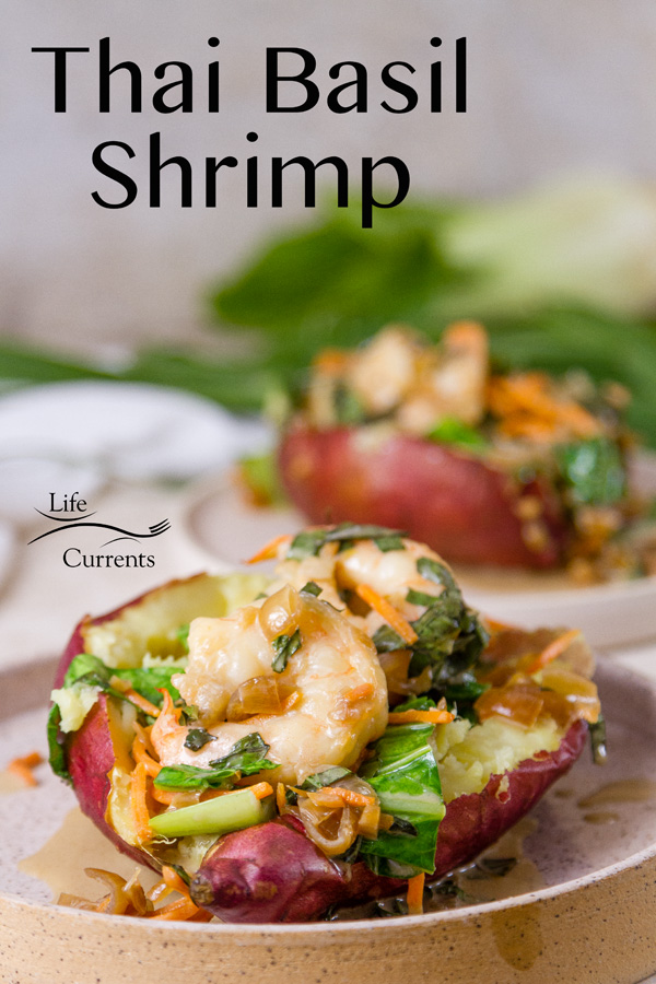 Thai Basil Shrimp with stir fried veggies in a baked sweet potato, two servings, on whit plates with bok choy and chives in the background