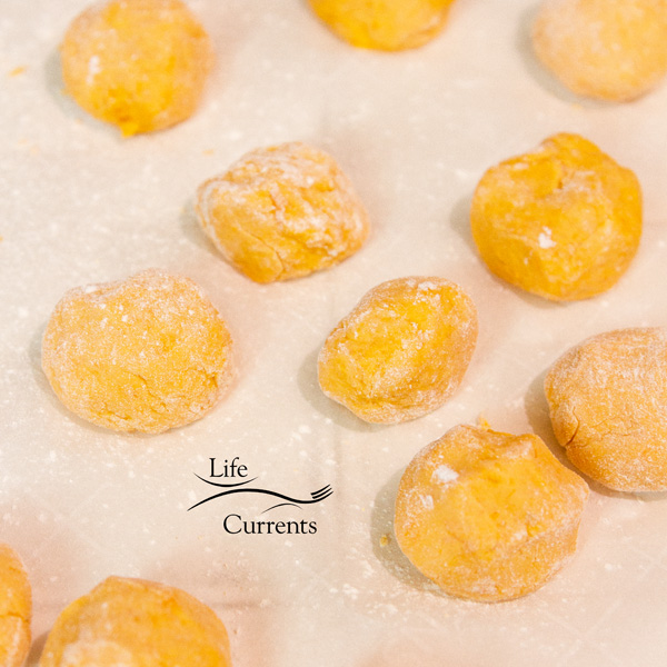 Uncooked sweet potato rice balls on parchment paper Uncooked sweet potato rice balls on parchment paper