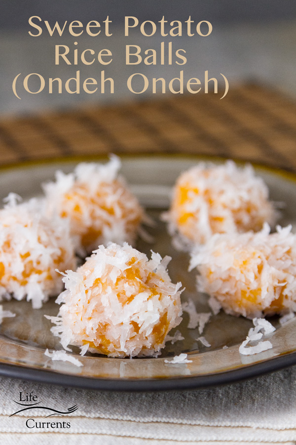 These Sweet Potato Rice Balls are little sweet dessert treats. There’s a hidden sweet surprise inside these Ondeh Ondeh. Sweet Potato Rice Balls in coconut (Ondeh Ondeh) on a grey plate with an Asian mat in the background