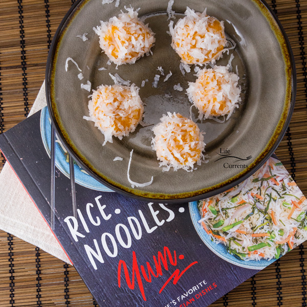 Sweet Potato Rice Balls (Ondeh Ondeh) a sweet treat with a cookbook review of Rice. Noodles. Yum. Sweet Potato Rice Balls or Ondeh Ondeh on a grey plate on top of the cookbook Rice. Noodles. Yum.