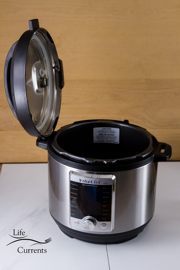 The Instant Pot with the lid resting in the side slot or handle 