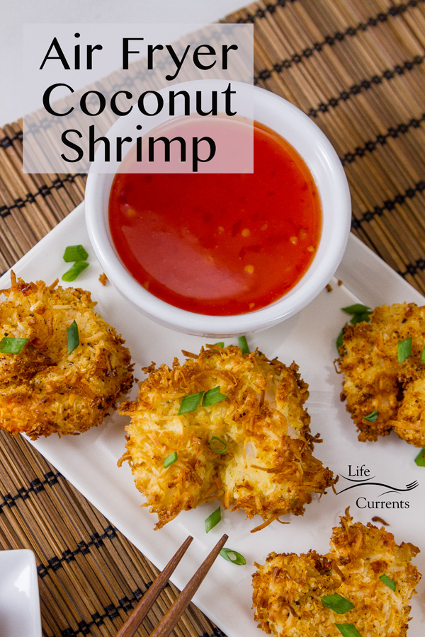 Air Fryer Coconut Shrimp on a white plate with a red dipping sauce on a wooden mat with a title