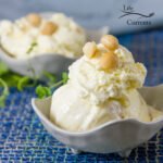 two bowls of ice cream topped with nuts on a blue background