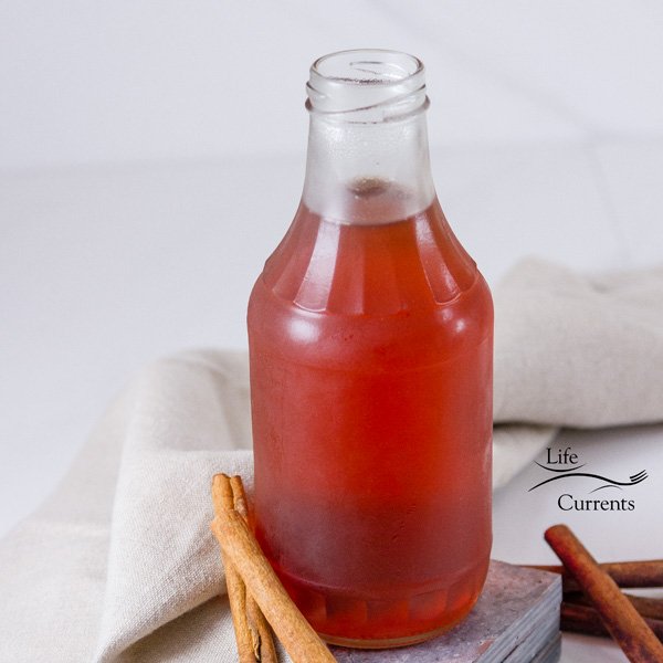 a square image of a glass jar filled with Cinnamon Simple Syrup