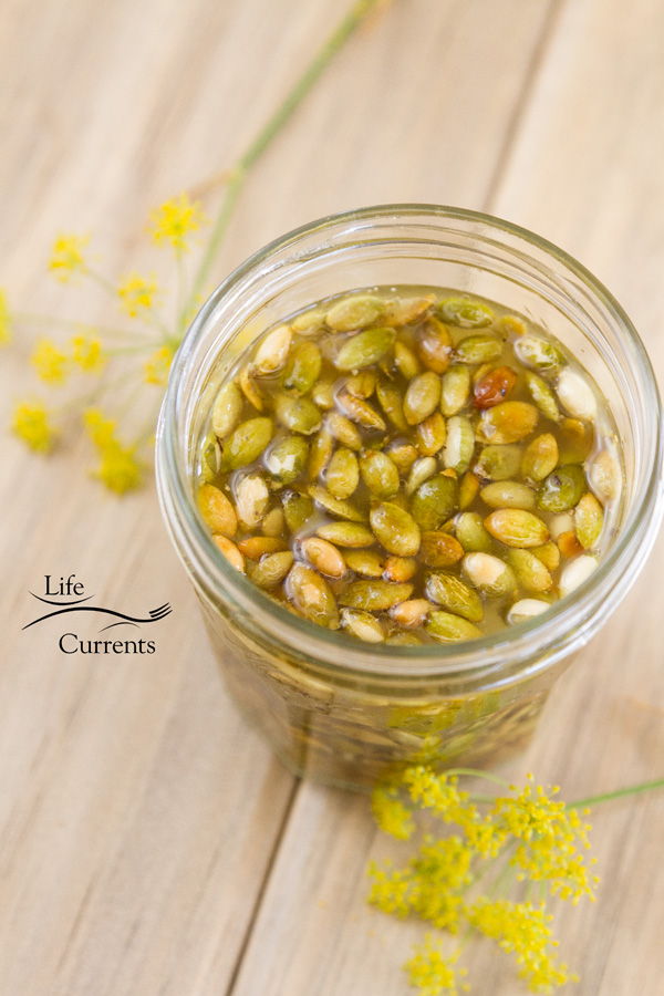 Looking down in a glass jar filled with Toasted Pumpkin Seed Vinaigrette on a wood background