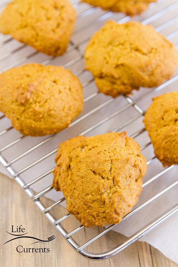 pumpkin cookies cooling on a rack with parchment paper in the background 