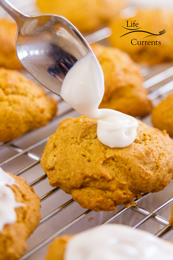 glazing the pumpkin cookie with glaze from a spoon 