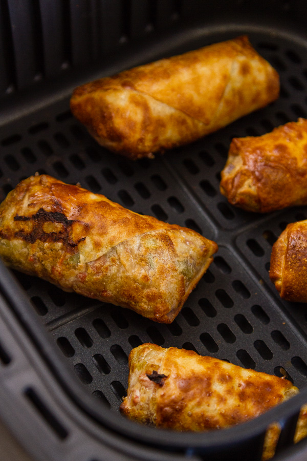 Egg Rolls in the basket of an air fryer 