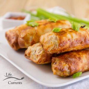a stack of egg rolls that were cooked in the air fryer and garnished with green onions