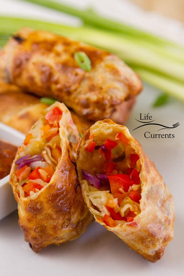 Vegetable egg rolls witg one cut open so you can see the inside 