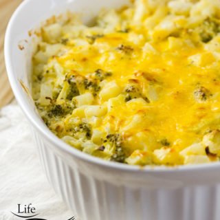 broccoli potato casserole in a white casseole dish on a white napkin