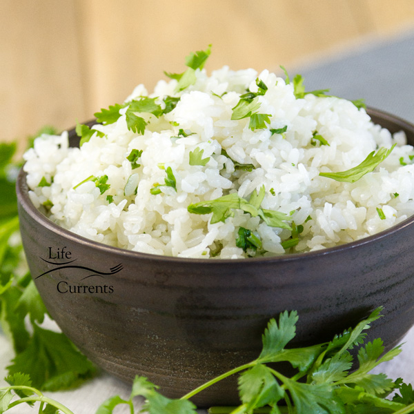 a black bowl full of rice with cilantro around it 