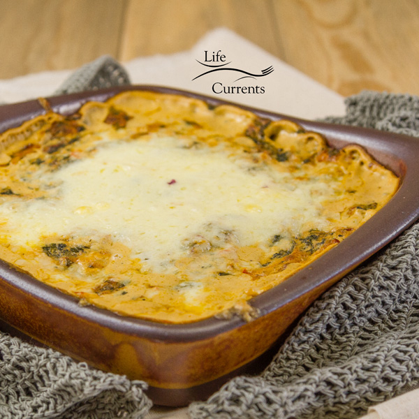 Cheesy Fiesta Spinach Dip – easy to make, cheesy and delicious dip in a clay pan right out of the oven gray hot pads next to the pan