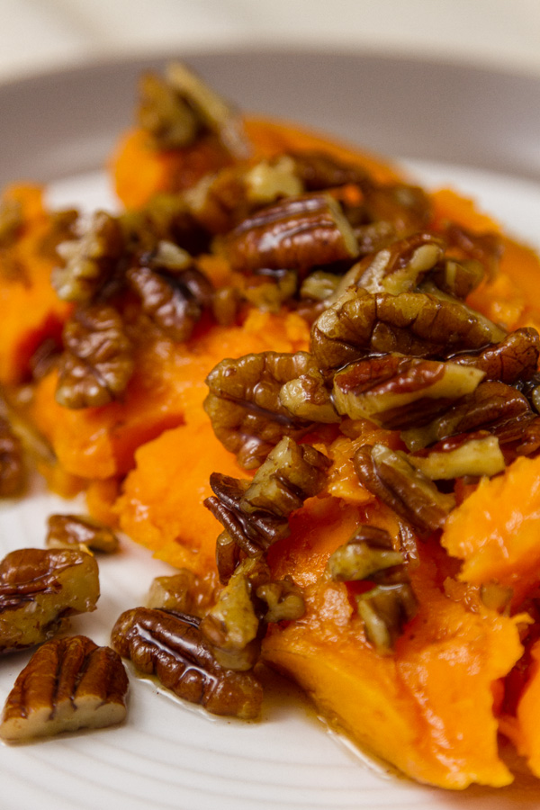 half od a sweet potato with pecan sauce on top 