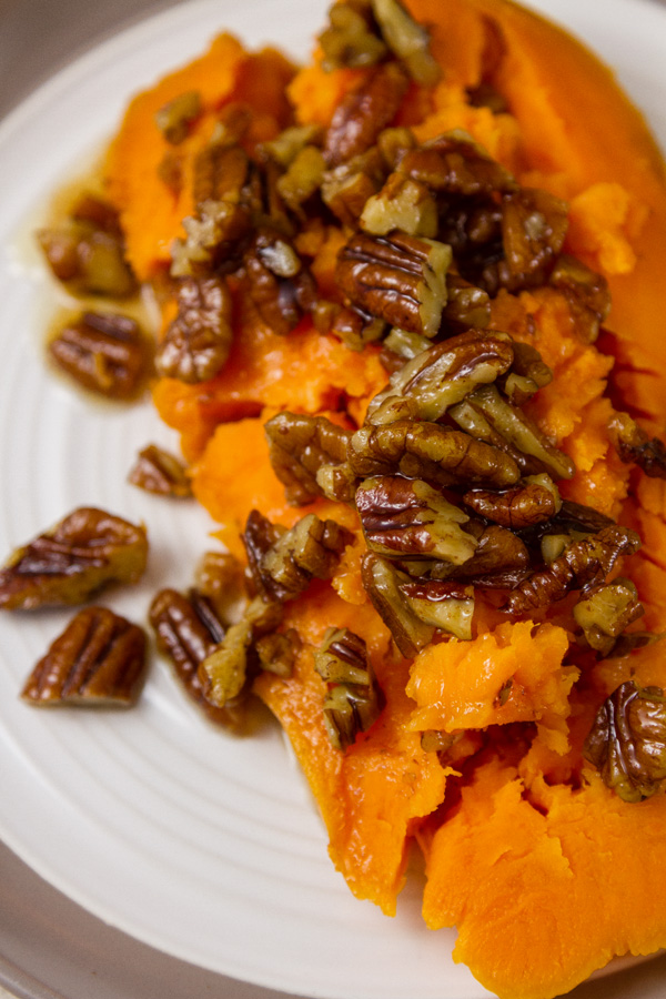 half of a baked sweet potato covered with pecans