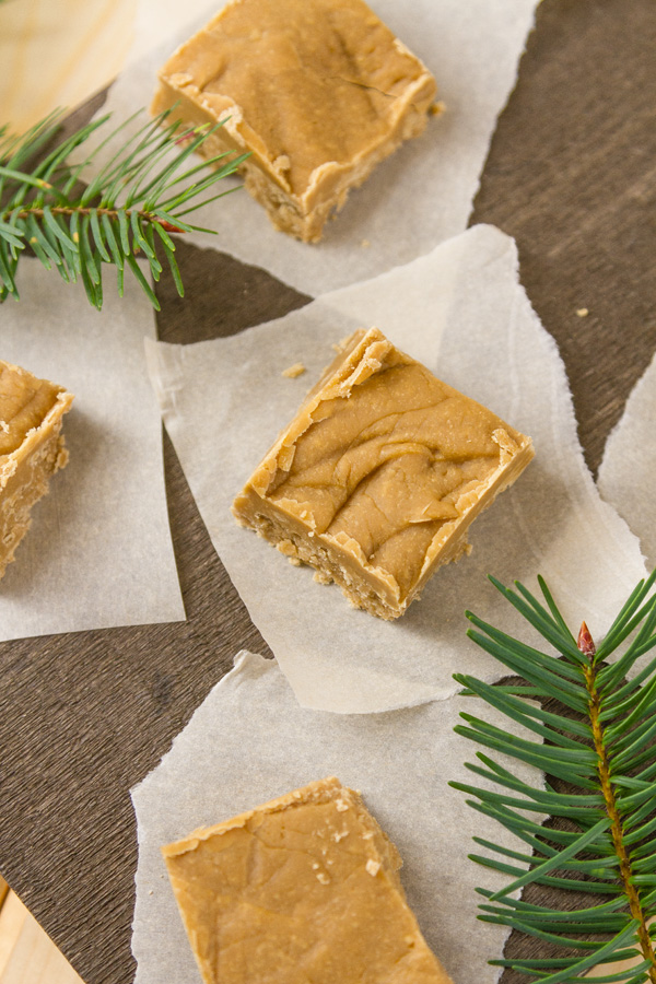 This buttery melt-in-your-mouth delicious old-fashioned Brown Sugar Fudge has the warm flavor of caramel and reminds me of a fabulous New Orleans praline. It’s perfect on a Christmas dessert tray or included in a cookie exchange. You'll want to keep this recipe handy, as gift giving season approaches. pieces of brown sugar fudge on pieces of parchment paper with fir branches